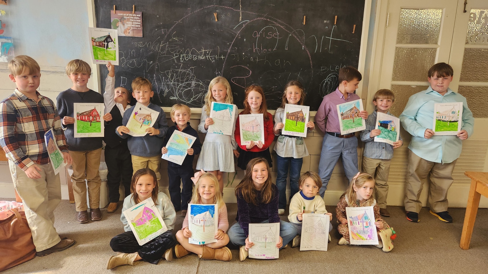 Children's Sunday School class holding artwork